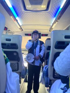 Petugas bimbingan ibadah menuntun jemaah melafalkan niat umrah di bus saat baru tiba di bandara Jeddah